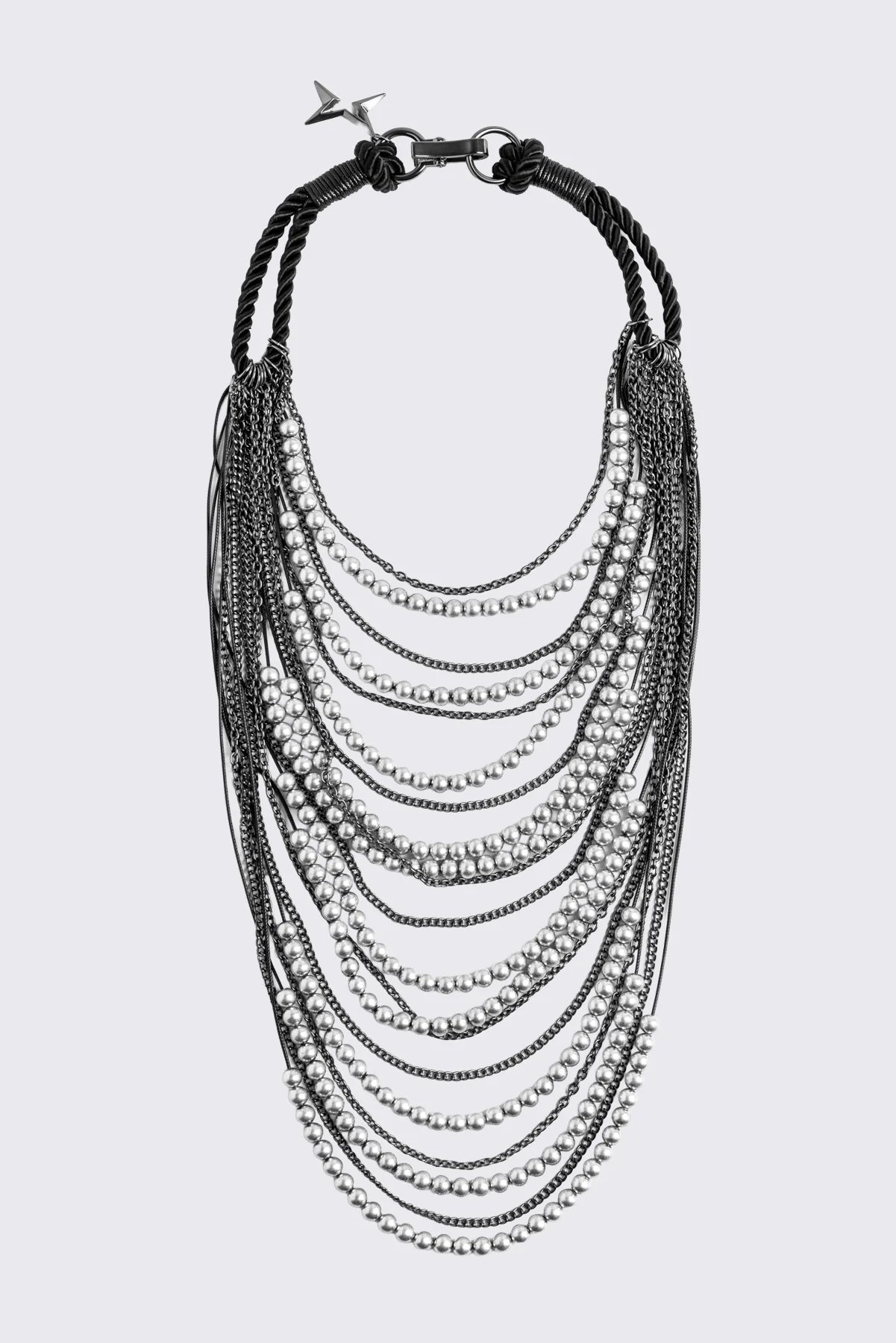 Silver layered chain necklace with beaded and curb chain strands, black knotted cord straps and charm pendant.
