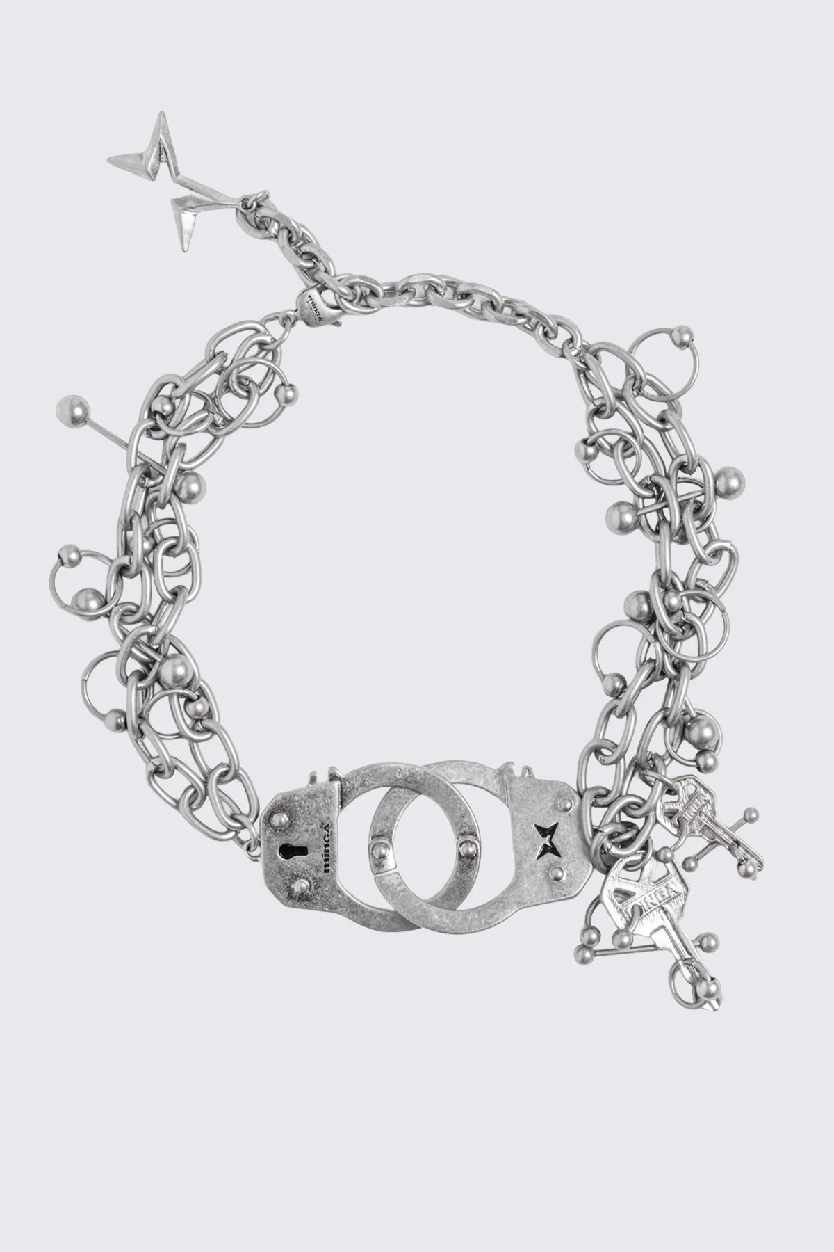 Chunky necklace in antique silver with handcuff, key and piercing charms in a grunge goth style.