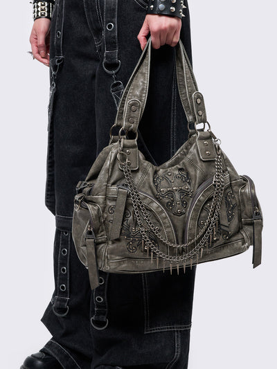 Grey washed faux leather shoulder bag with studded cross patches, spikes and chains accents. Multiple pockets and grunge-style.