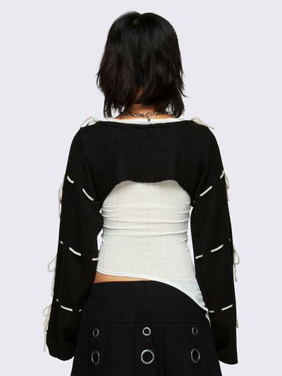black knitted shrug with white tie bows, designed in a bolero style with long, wide sleeves.
