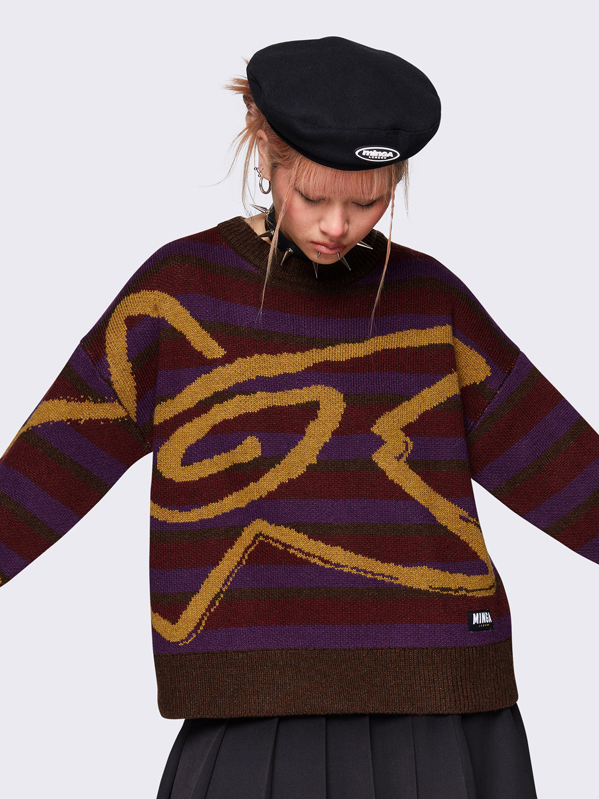 Striped knit jumper in brown, burgundy and purple with a swirl star design in orange and a loose fit.