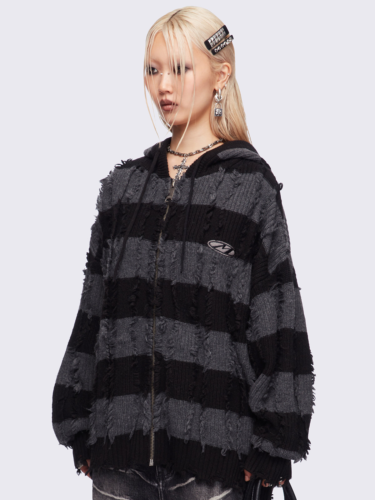 Hooded chunky knit cardigan in black and grey stripes with distressed details.