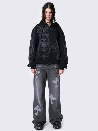 Oversized black zip-up hoodie with grunge graphic prints, drawstring hood, and ribbed trims. Y2K and acubi-inspired streetwear.