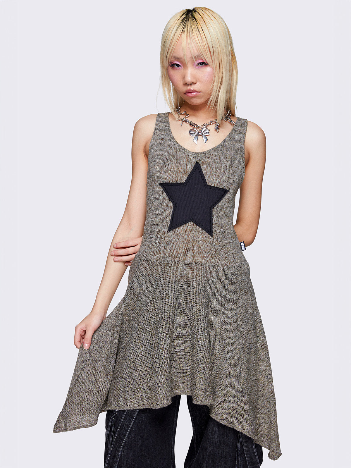 Khaki green sleeveless knitted dress with a black star front patch, featuring a mini asymmetrical length for a stylish and unique look.