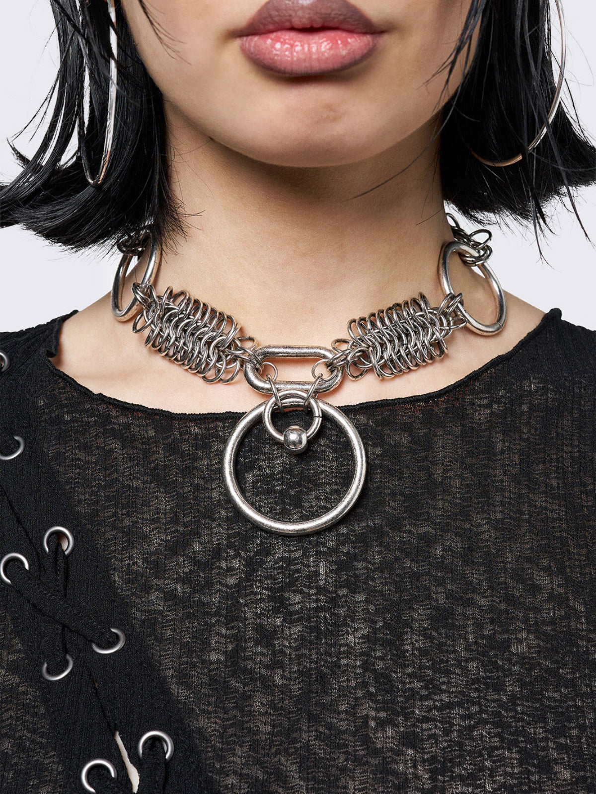 Chunky choker necklace with an O-ring pendant and interlocking rings. Features an adjustable length, lobster clasp fastening, and an antique-silver finish for a bold, edgy look.
