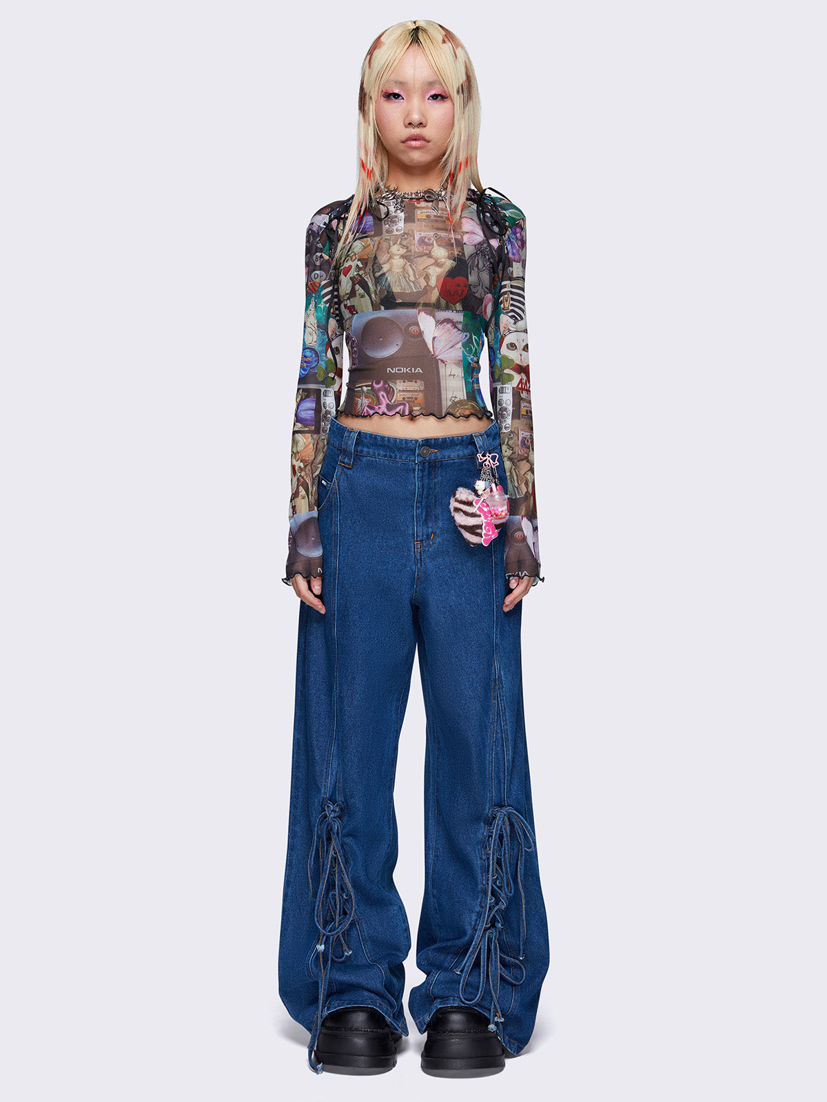 Printed mesh crop top with all over pop art collage graphic print, black lace up details, reverse stitching, and lettuce edge trims.