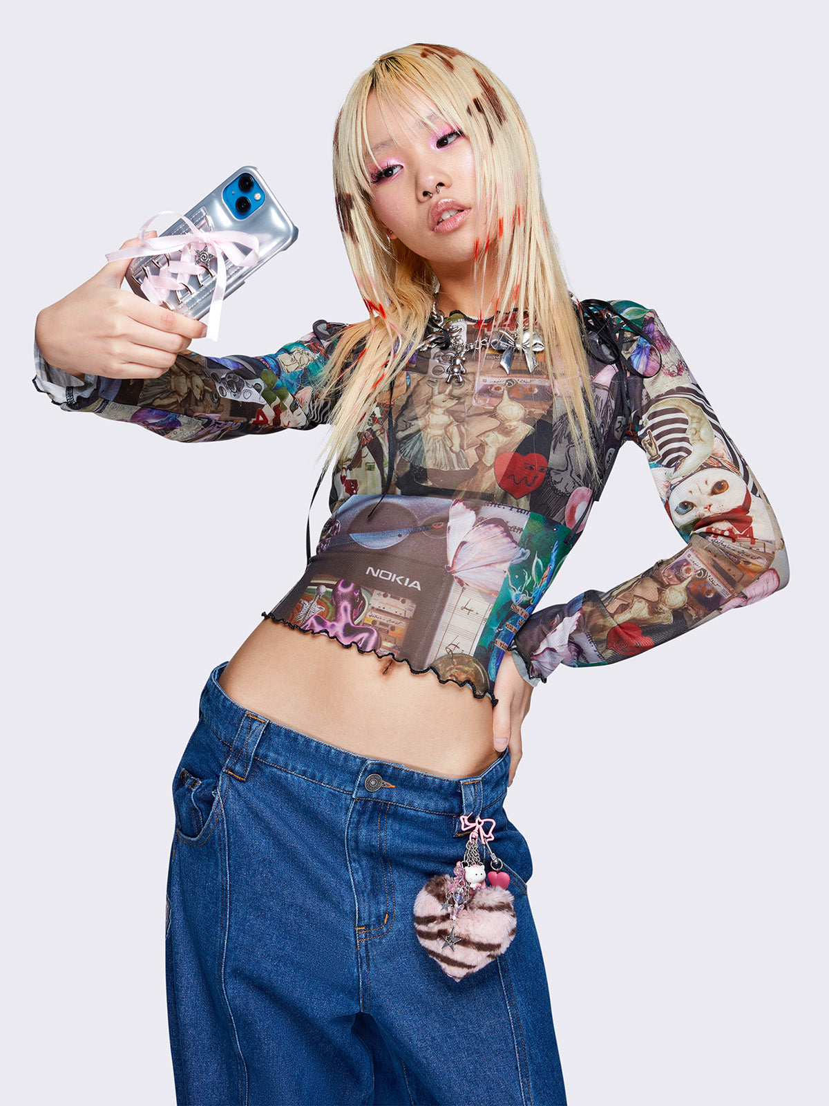 Printed mesh crop top with all over pop art collage graphic print, black lace up details, reverse stitching, and lettuce edge trims.