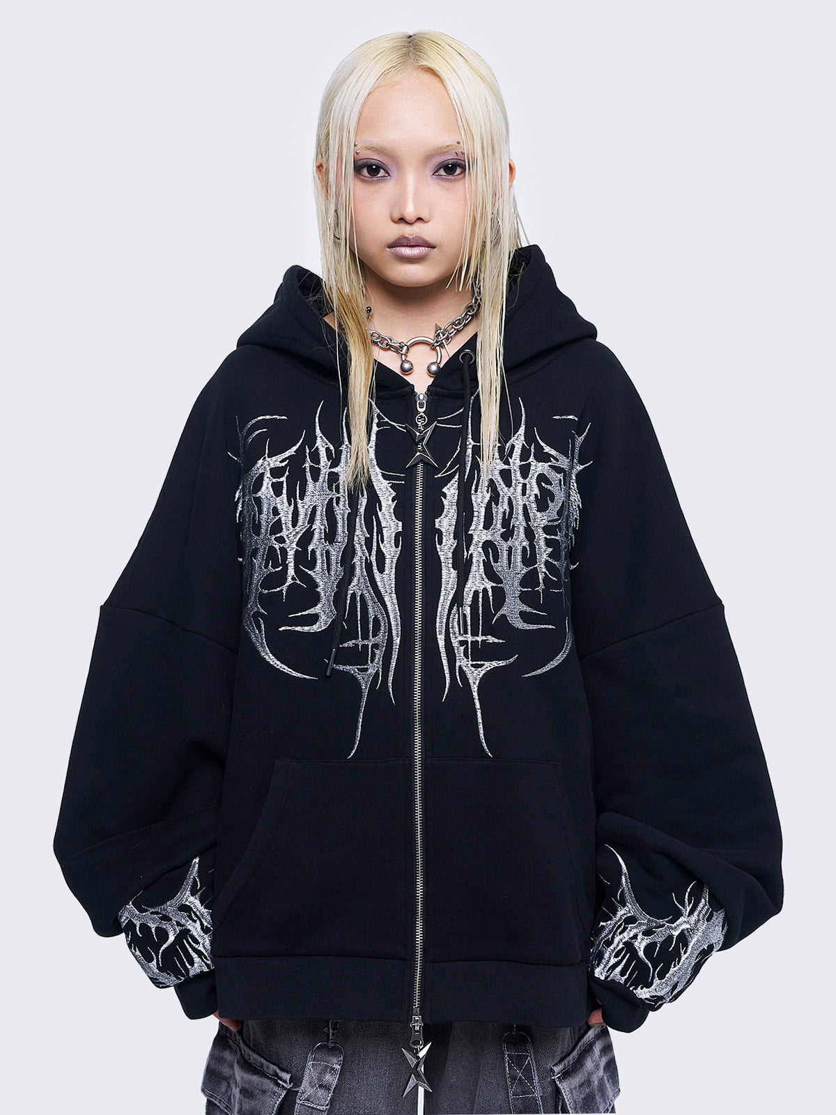 Black zip up hoodie jacket featuring a grey sigilism embroidery on front and sleeves and a oversized fit. 