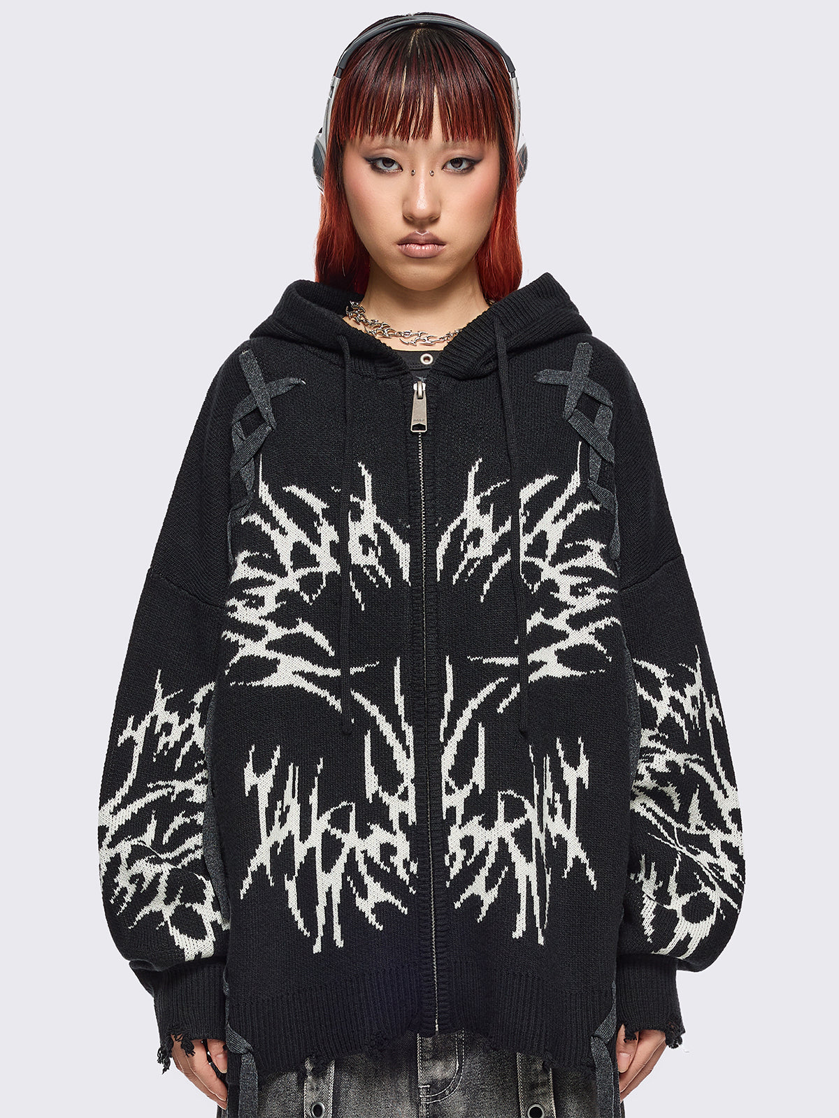 Black hooded chunky knit cardigan featuring white sigilism graphic design, contrast grey lace up details and distressed trims.