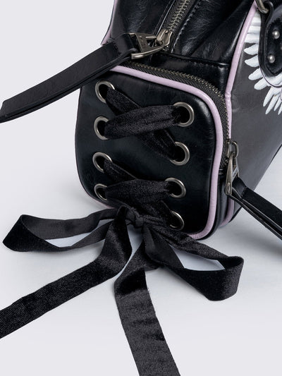Black bowling bag with white wings graphic print, 3D cross metal stud and side exterior pockets with lace up bows.