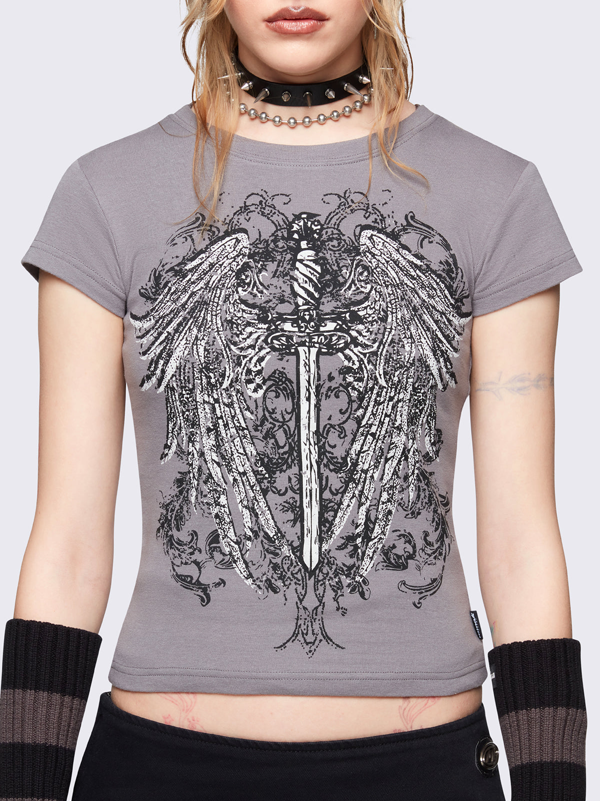 Grey graphic baby tee featuring a angel wings dagger front print. Cropped length and short sleeves.