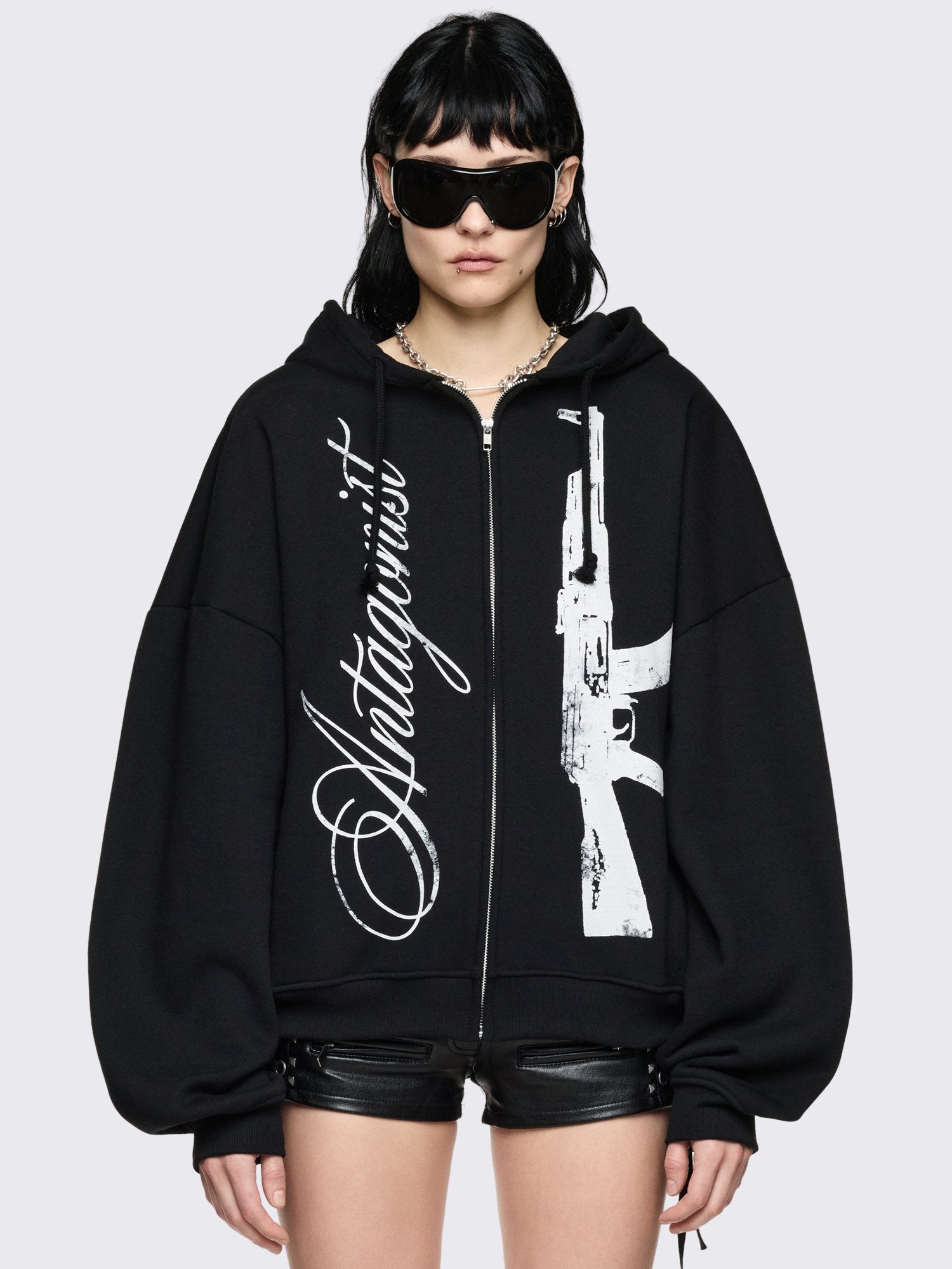 Black oversized zip up hoodie with "Antagonist" gun graphic front print.