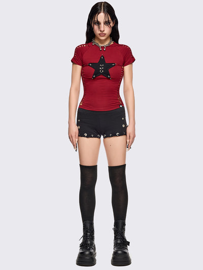 Red slitweave baby tee featuring a black front star patch with piercings.