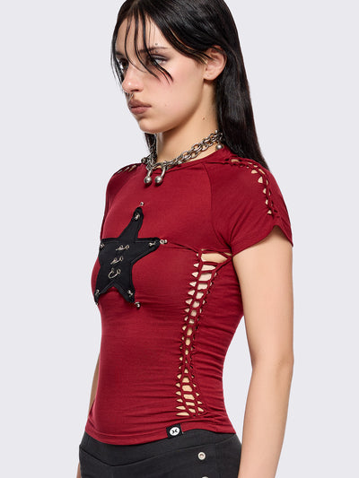 Red slitweave baby tee featuring a black front star patch with piercings.