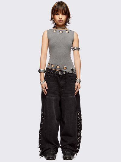 Grey asymmetric top featuring chunky eyelets along neckline and hem and boat neckline.