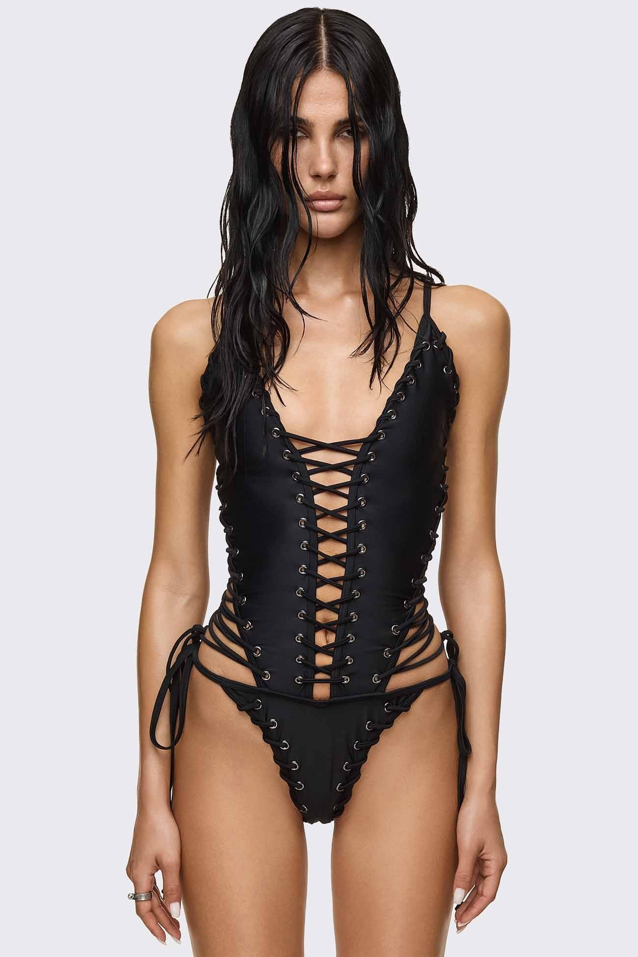 Black polyamide swimsuit with lace-up grommets, cutout sides and corset shape in a goth-inspired style.