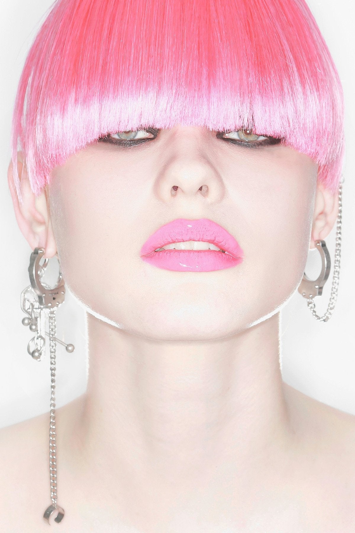 Silver metal hoop earring with key charm, chain ear cuff and piercing details in a grunge goth style.