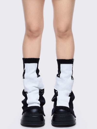 Black knitted flare leg warmers featuring a white chunky cross patch 