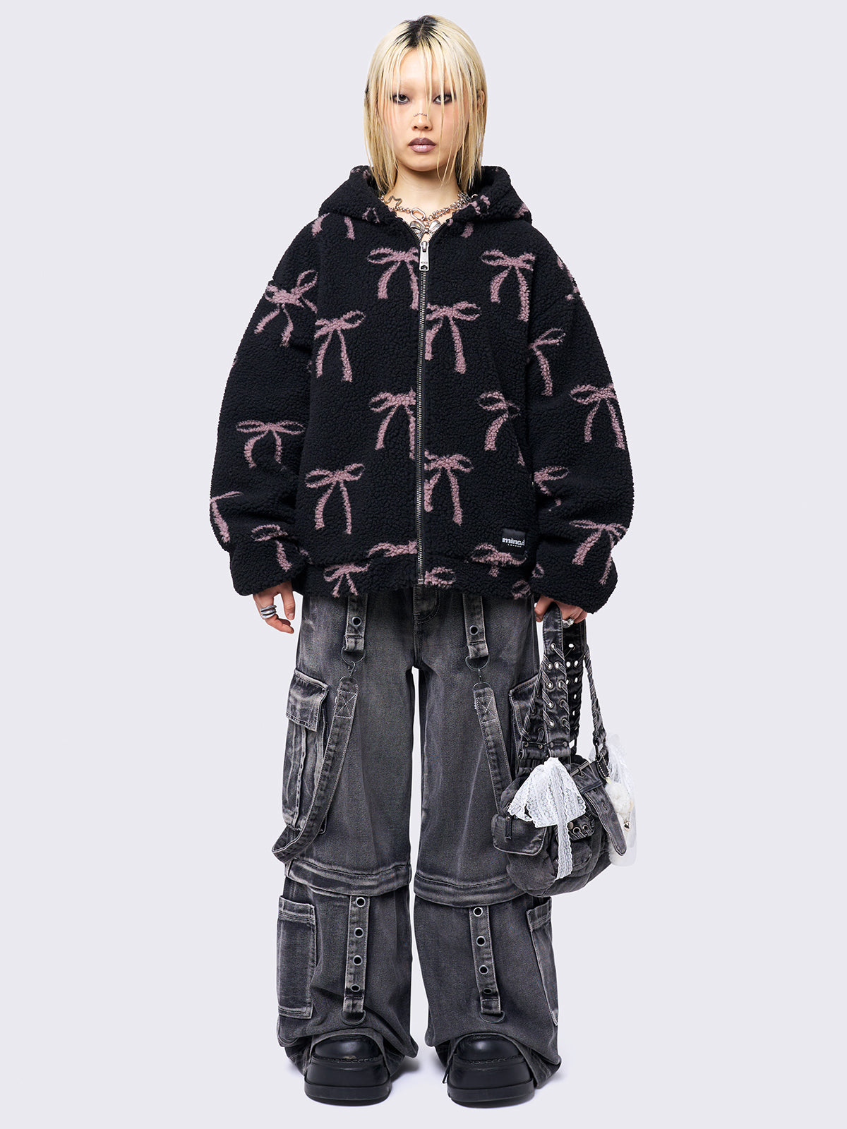 Black borg fleece hoodie jacket with an all-over pink bows design. Features an oversized fit and zip fastening.