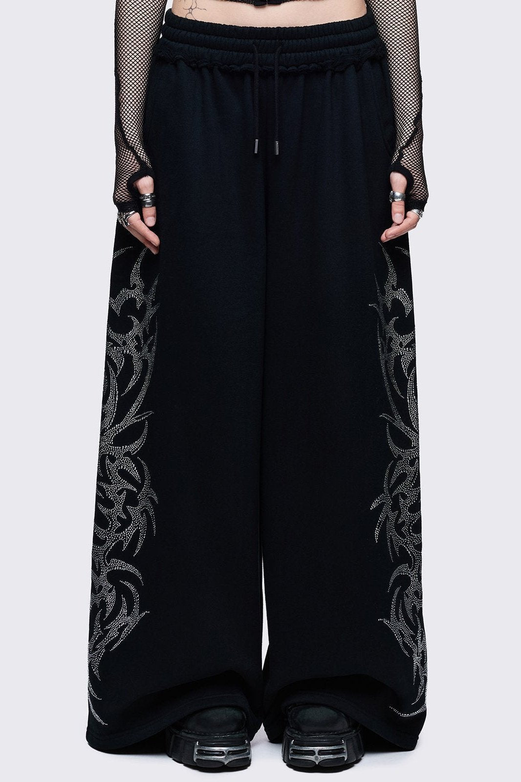 Black cotton sweatpants with sigil rhinestone side graphics, wide leg relaxed fit in a cyber grunge style.