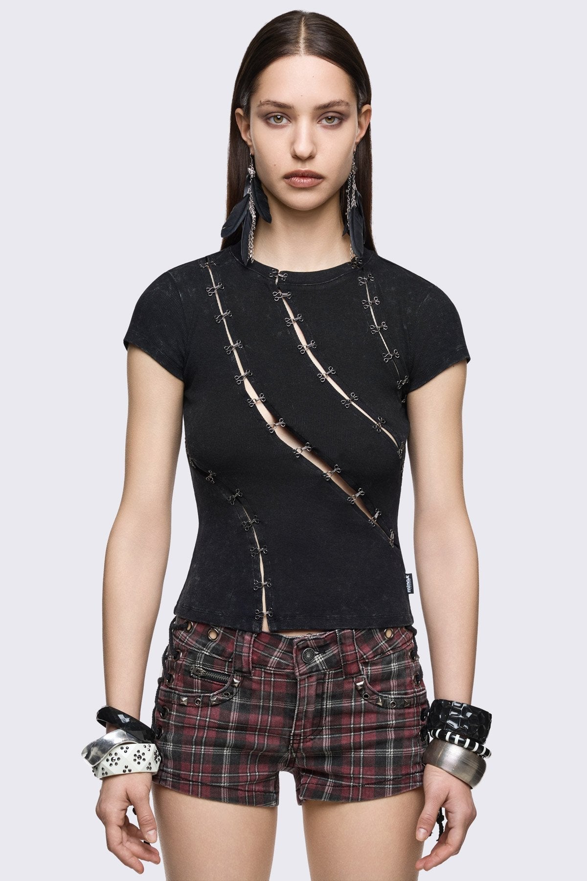 Black washed ribbed cotton baby tee with diagonal hook-and-eye cutouts in a grunge-inspired fitted style.