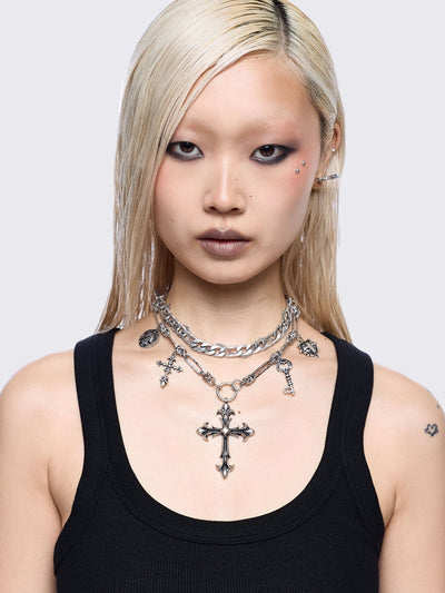 Silver chunky layered necklace featuring cross, key and medallion pendants.