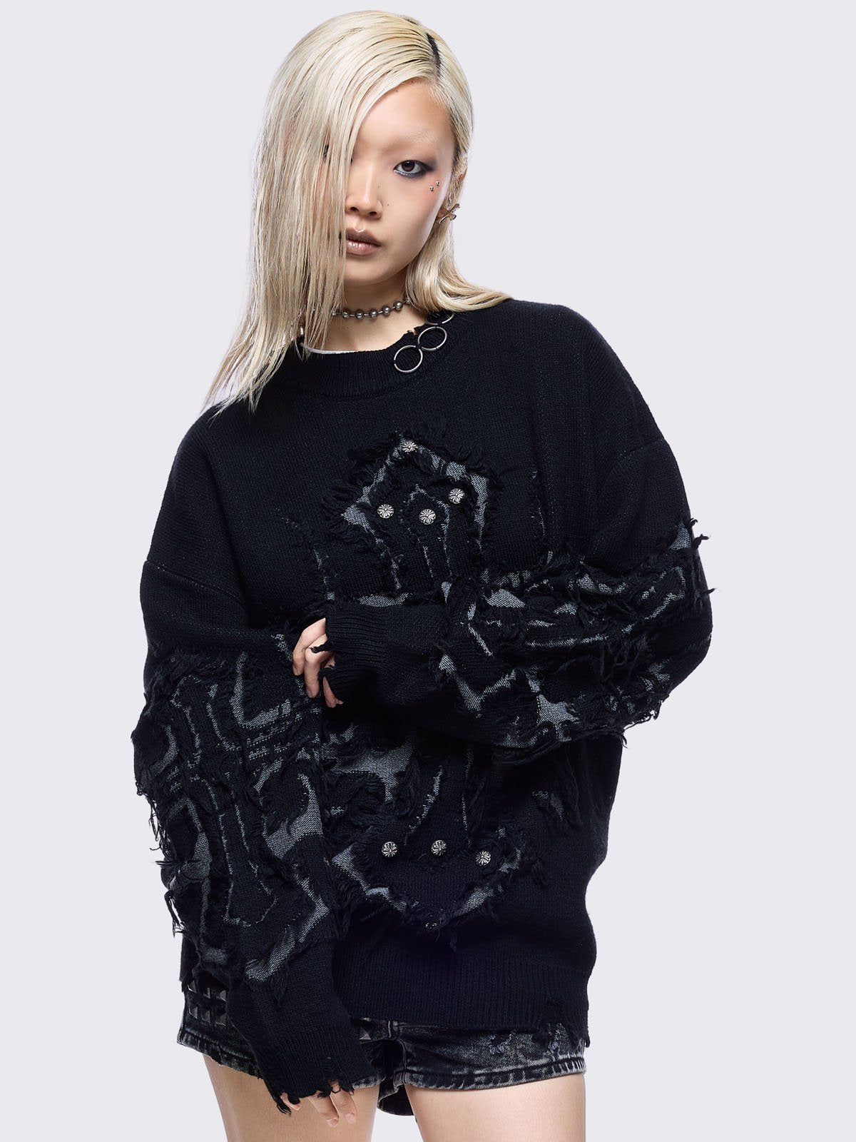 Black knitted jumper featuring frayed crosses design and stud and O-ring details.