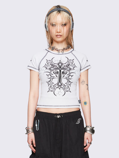 Off-white graphic raglan baby tee with tribal cross print and black contrast stitching.