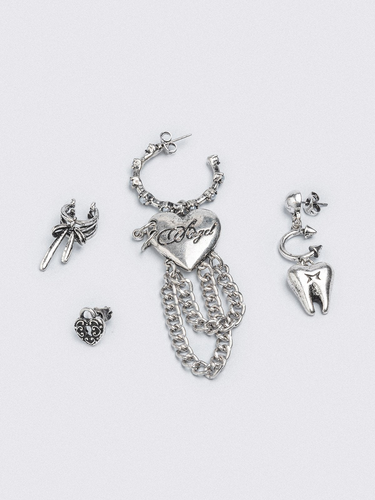 Silver 4pc layering earring set featuring heart and tooth pendant in chunky hoops, studs and ear cuff style.