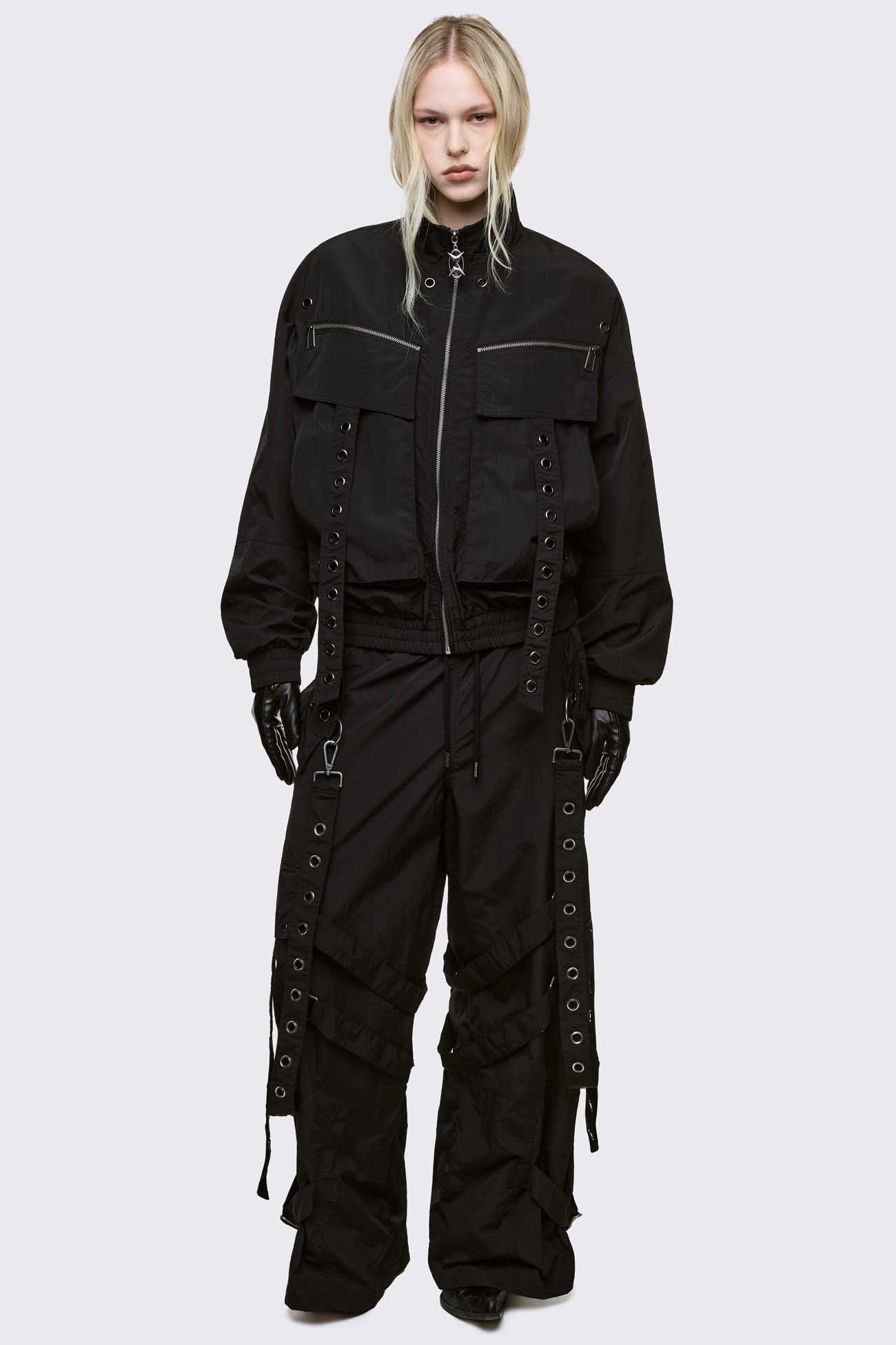 Black boxy oversized windbreaker jacket with straps and metal hardware details. 