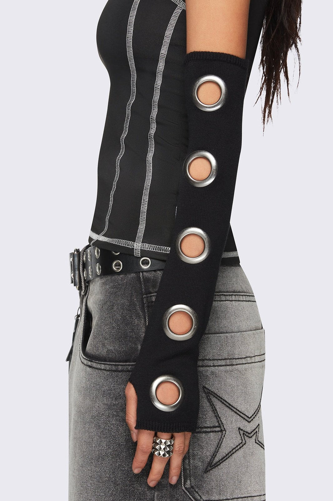 Black arm warmers with metallic hole details and thumbhole cuffs.