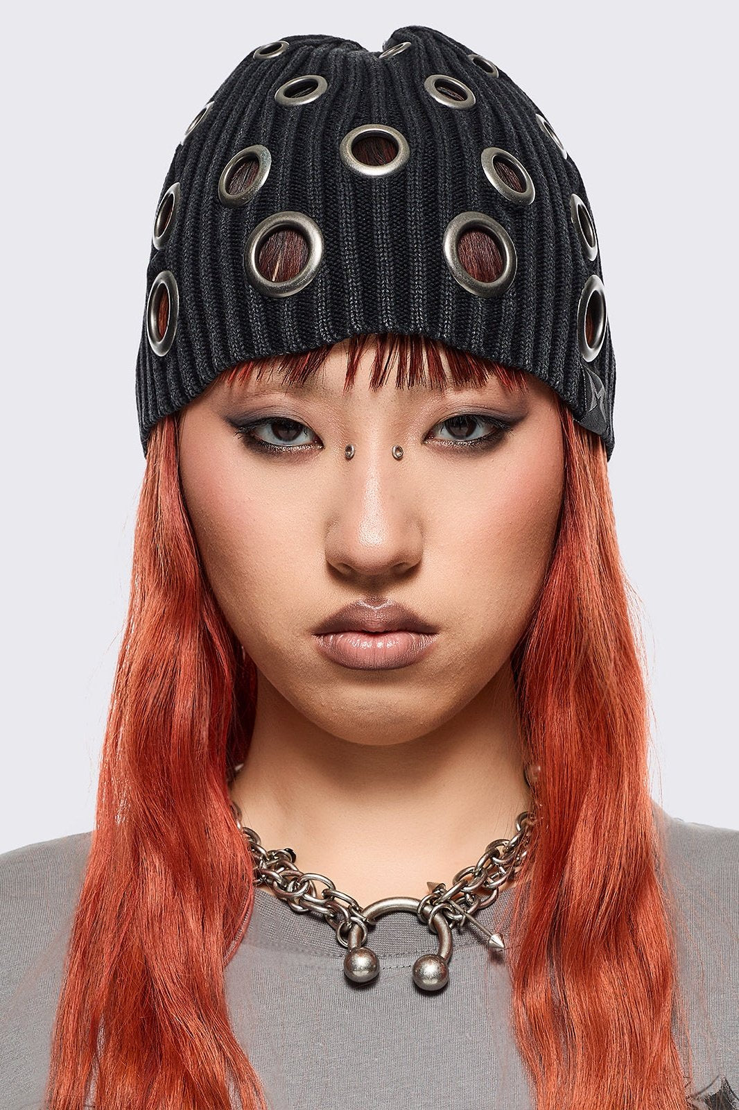 Black ribbed knit beanie with chunky silver eyelets.