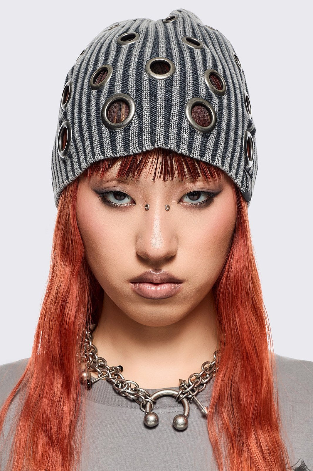 Grey ribbed knit beanie with chunky silver eyelets.