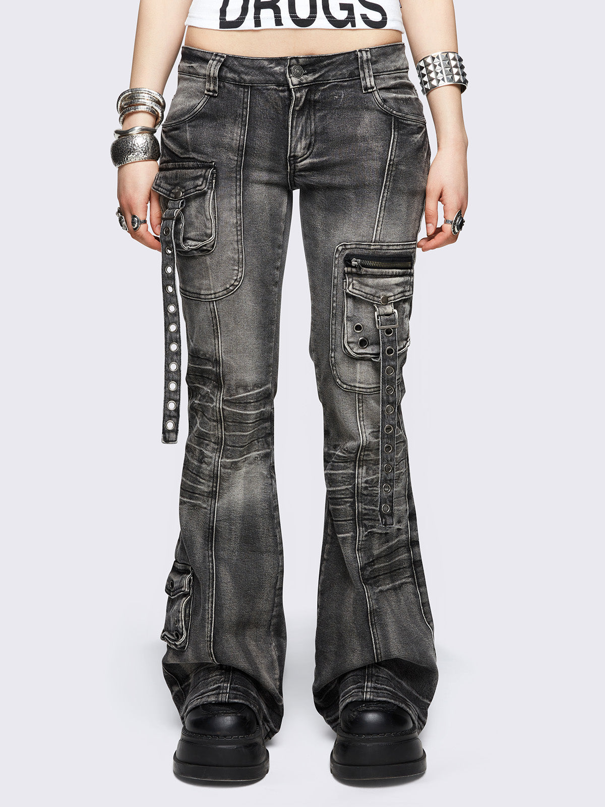 Black washed cargo flared jeans with utility pockets and straps.