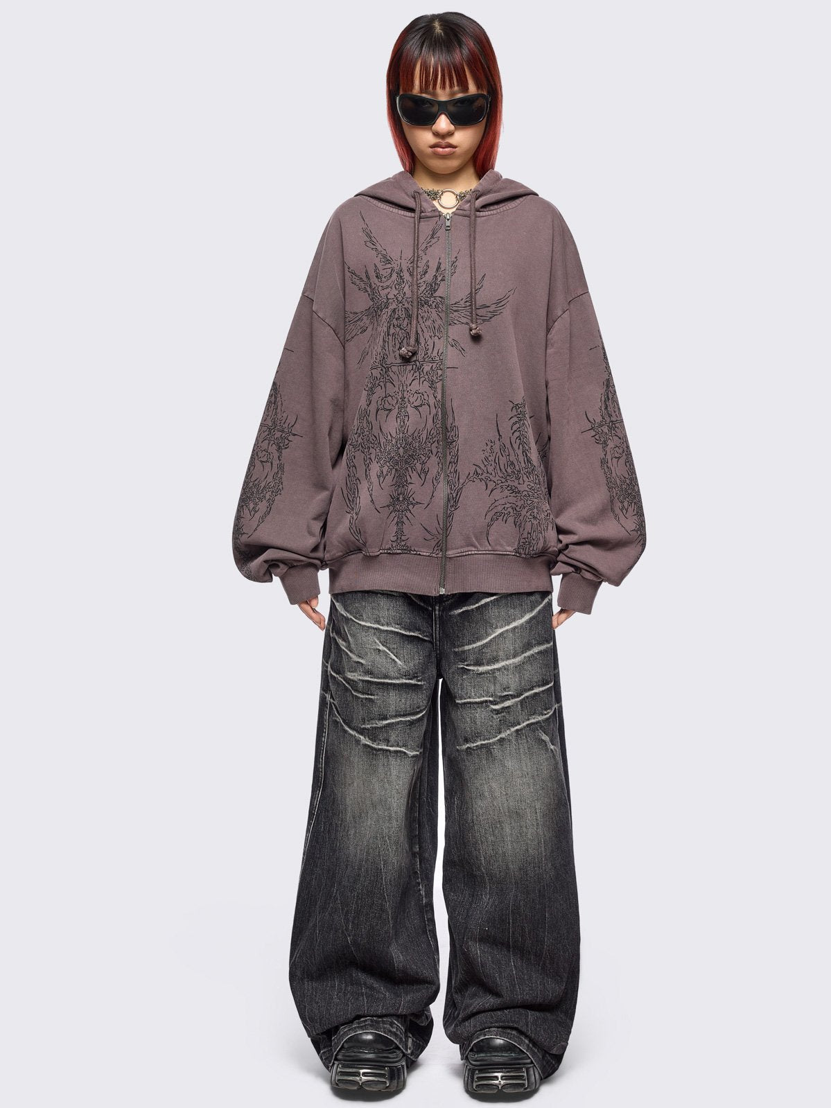 Washed brown zip-up hoodie jacket with grunge graphic prints on the front and sleeves.