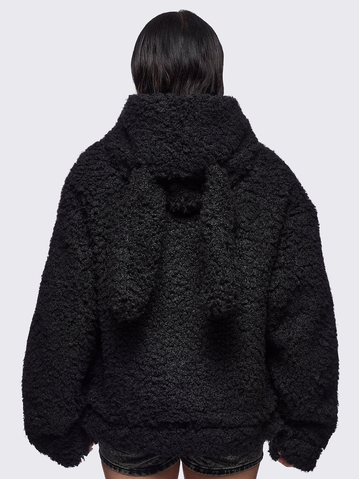 Black faux fur coat featuring a bunny ear hood and faux leather details with silver studs.