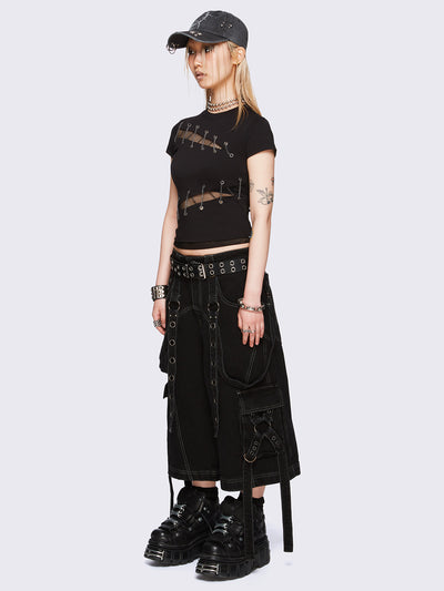 Black baby tee with diagonal fishnet cut-outs, eyelet and chain lace-up details, and short sleeves.