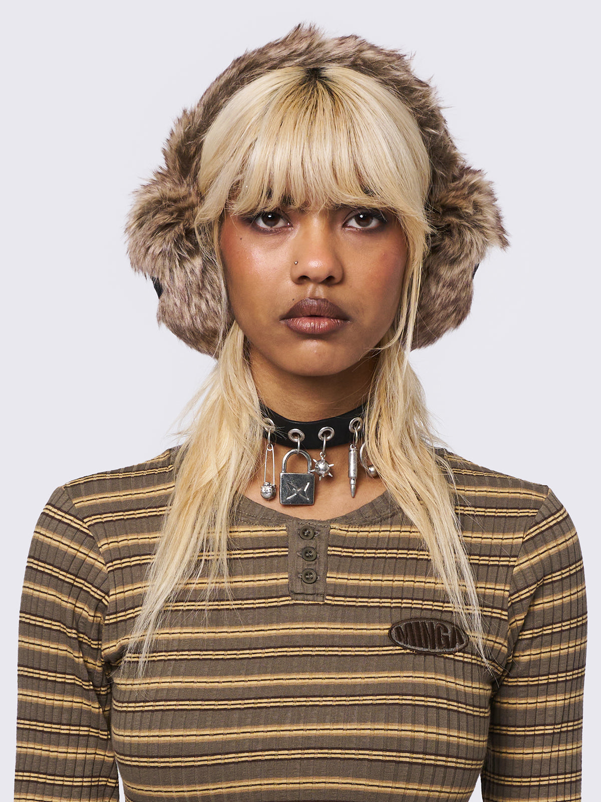 Faux fur earmuffs in beige and brown featuring stars embroidered patch in black.