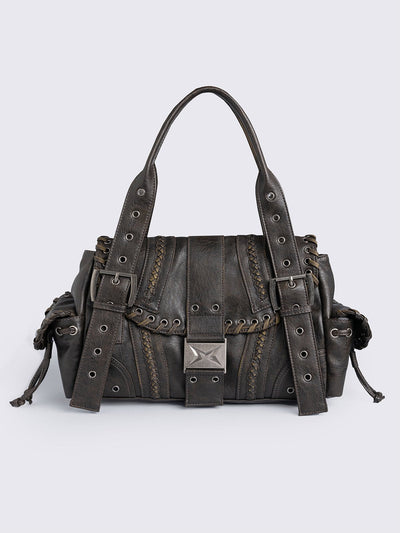 Brown faux leather shoulder bag featuring lace ups, eyelets, buckles and multiple pockets.