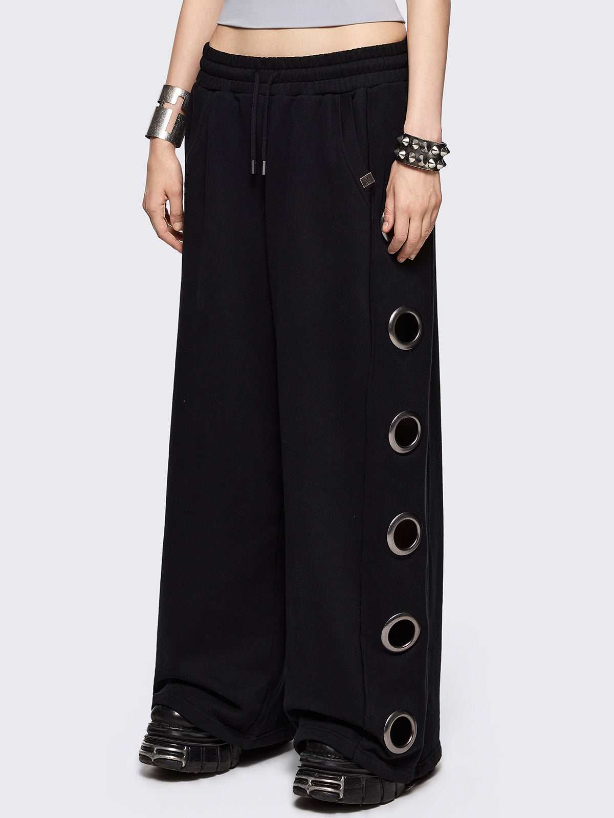 Black wide leg sweatpants with chunky silver eyelets.