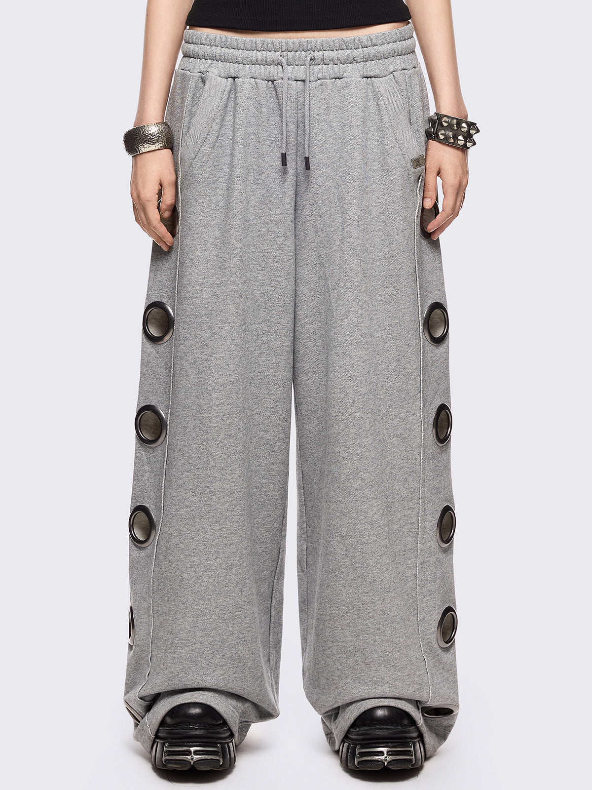 Grey marl wide leg sweatpants with chunky silver eyelets.
