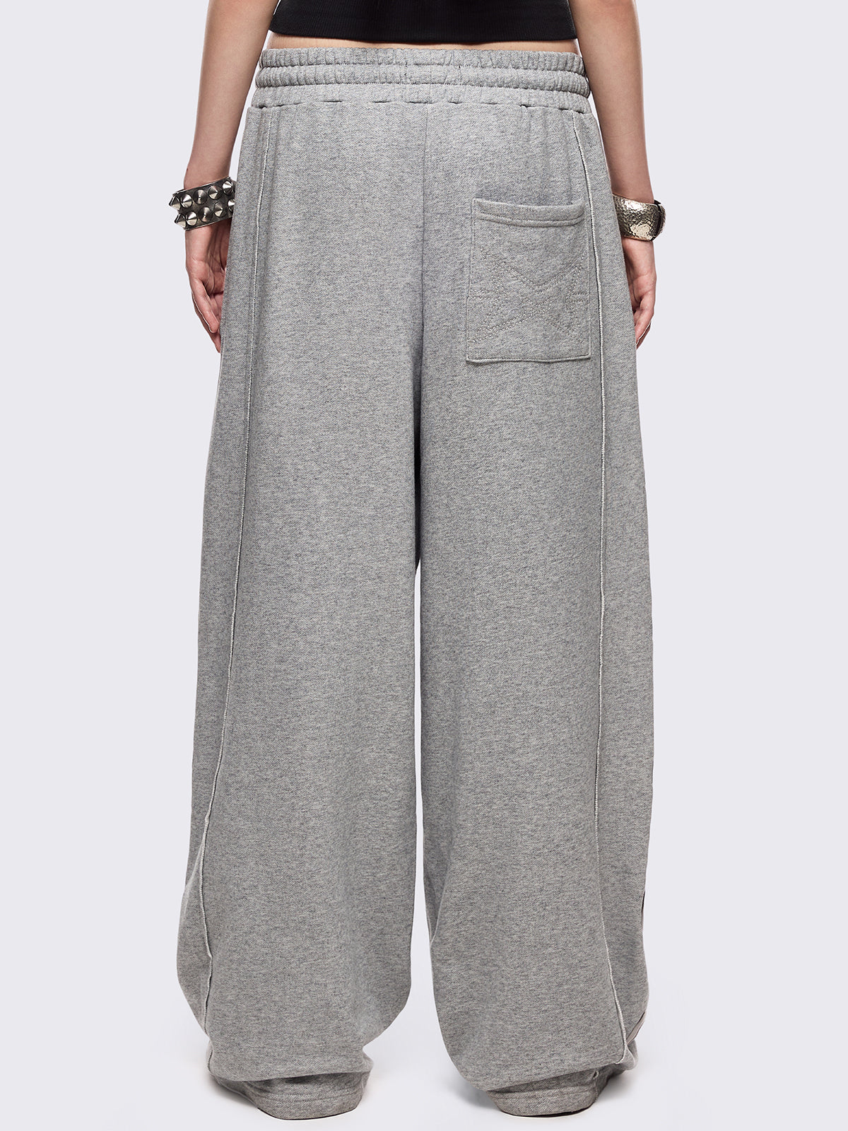 Grey marl wide leg sweatpants with chunky silver eyelets.