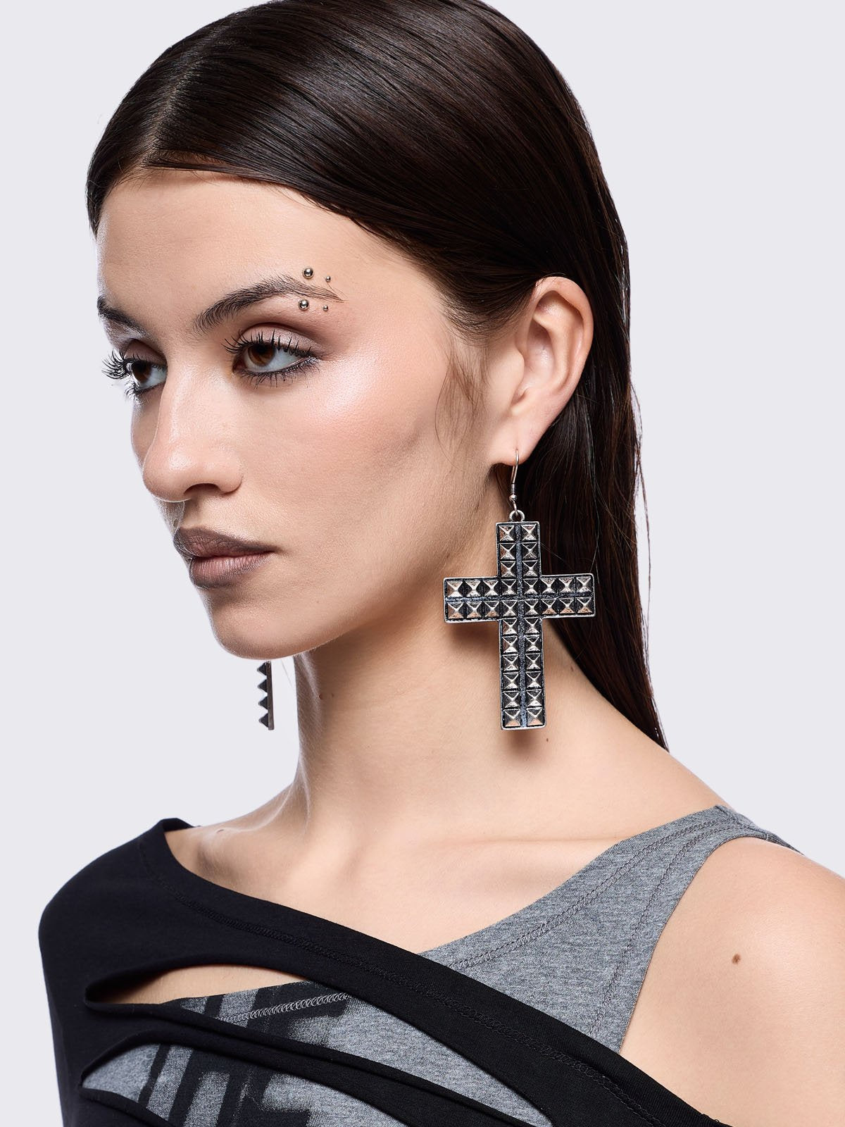 Silver dangle earrings featuring a studded cross design pendants