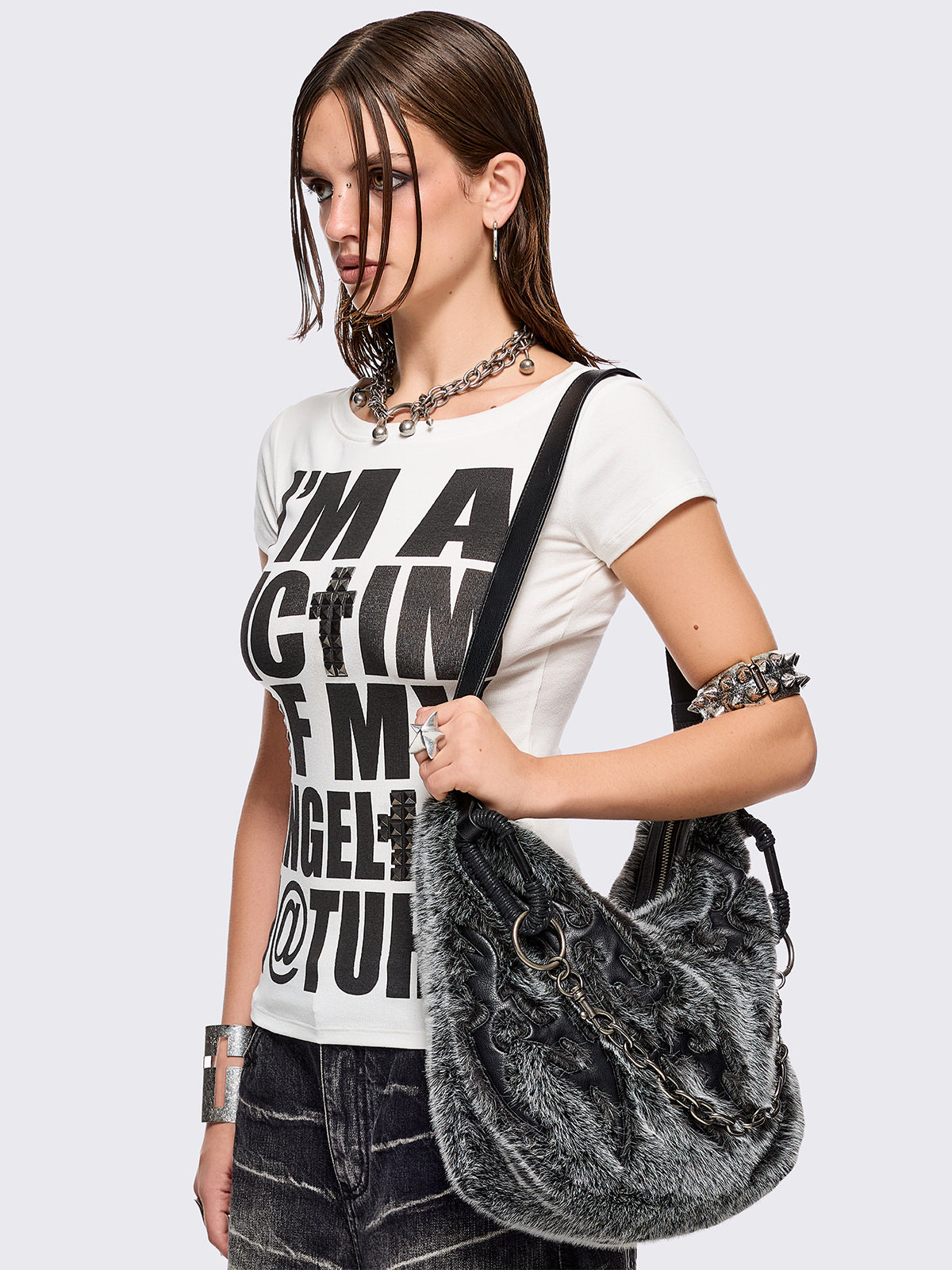 Black and grey faux fur shoulder bag with sigilism patches and silver chain detail.
