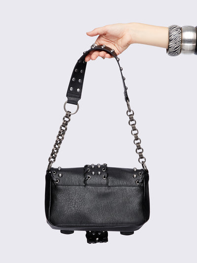 Black grunge-style shoulder bag with silver studs, star detail, chain strap, and buckle accents – edgy festival or streetwear accessory