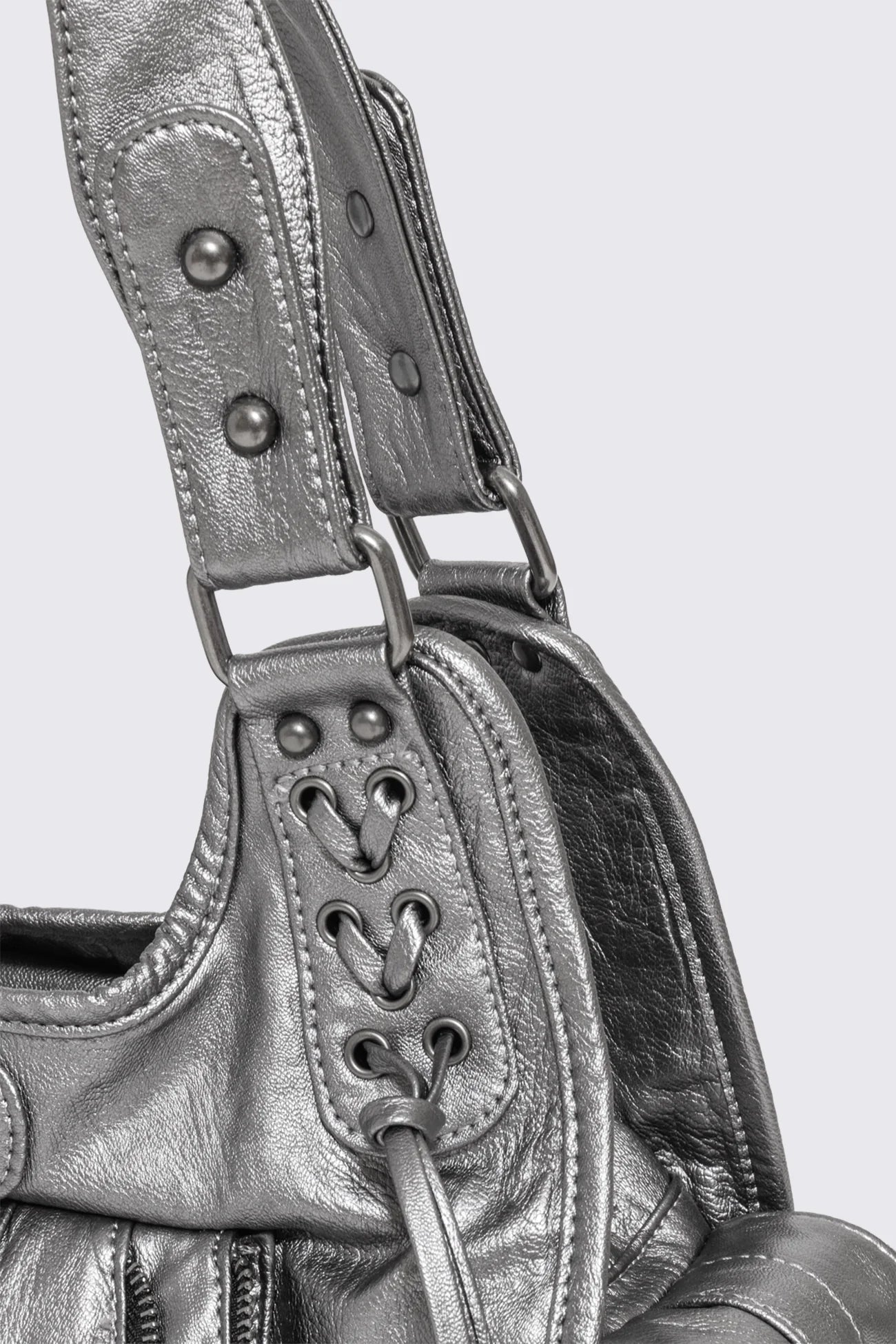 Silver faux leather shoulder bag with lace-up front, zip pockets and antique-silver hardware in a grunge Y2K style.
