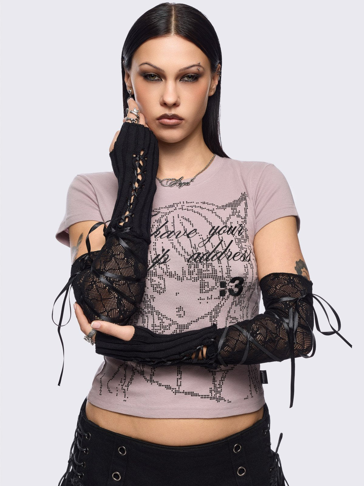 Black knit arm warmers featuring fishnet layer and lace up details.