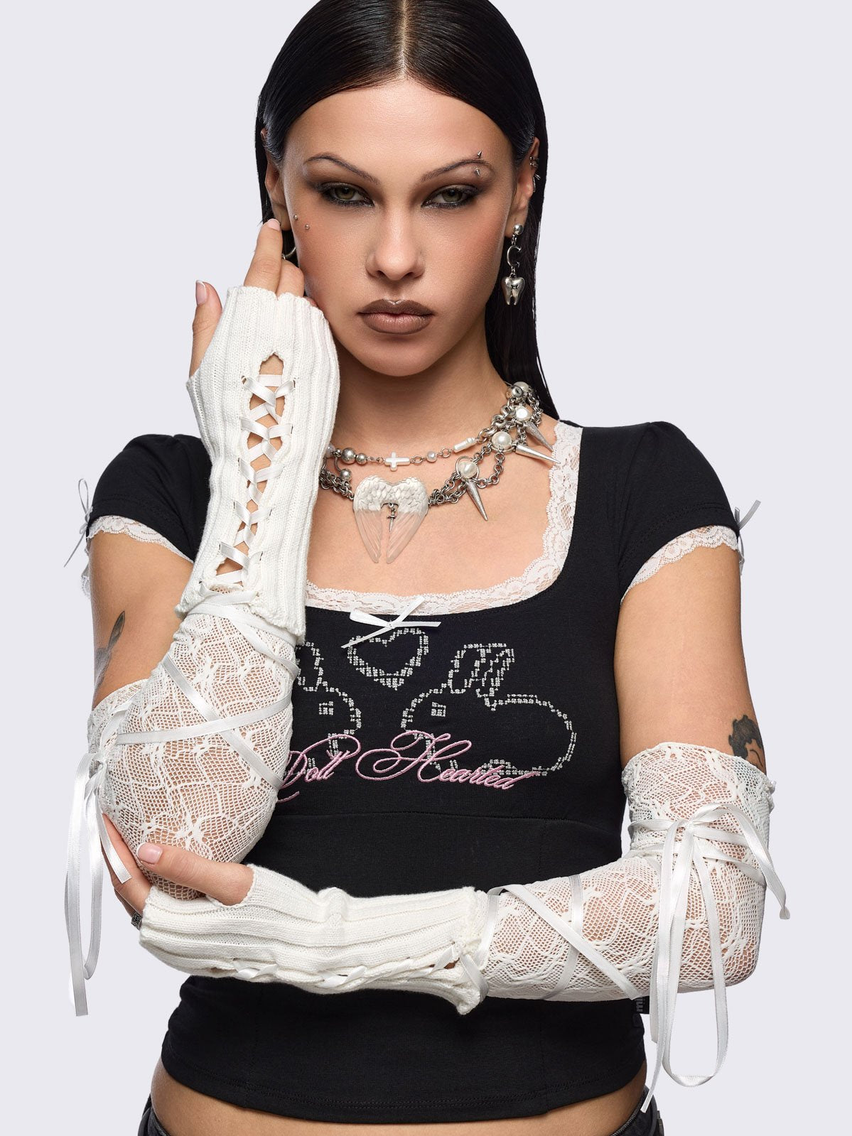 White knit arm warmers with fishnet layer and lace up details.