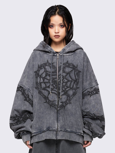 Grey distressed wash zip-up hoodie with a black barbed wire and spiderweb graphic, oversized fit, and dropped shoulders for a bold grunge aesthetic.