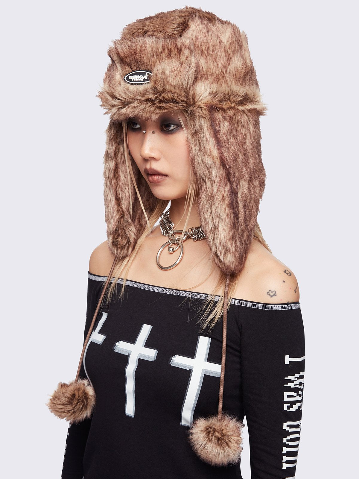 Beige faux fur trapper hat with minga rubber logo detail and ear flaps